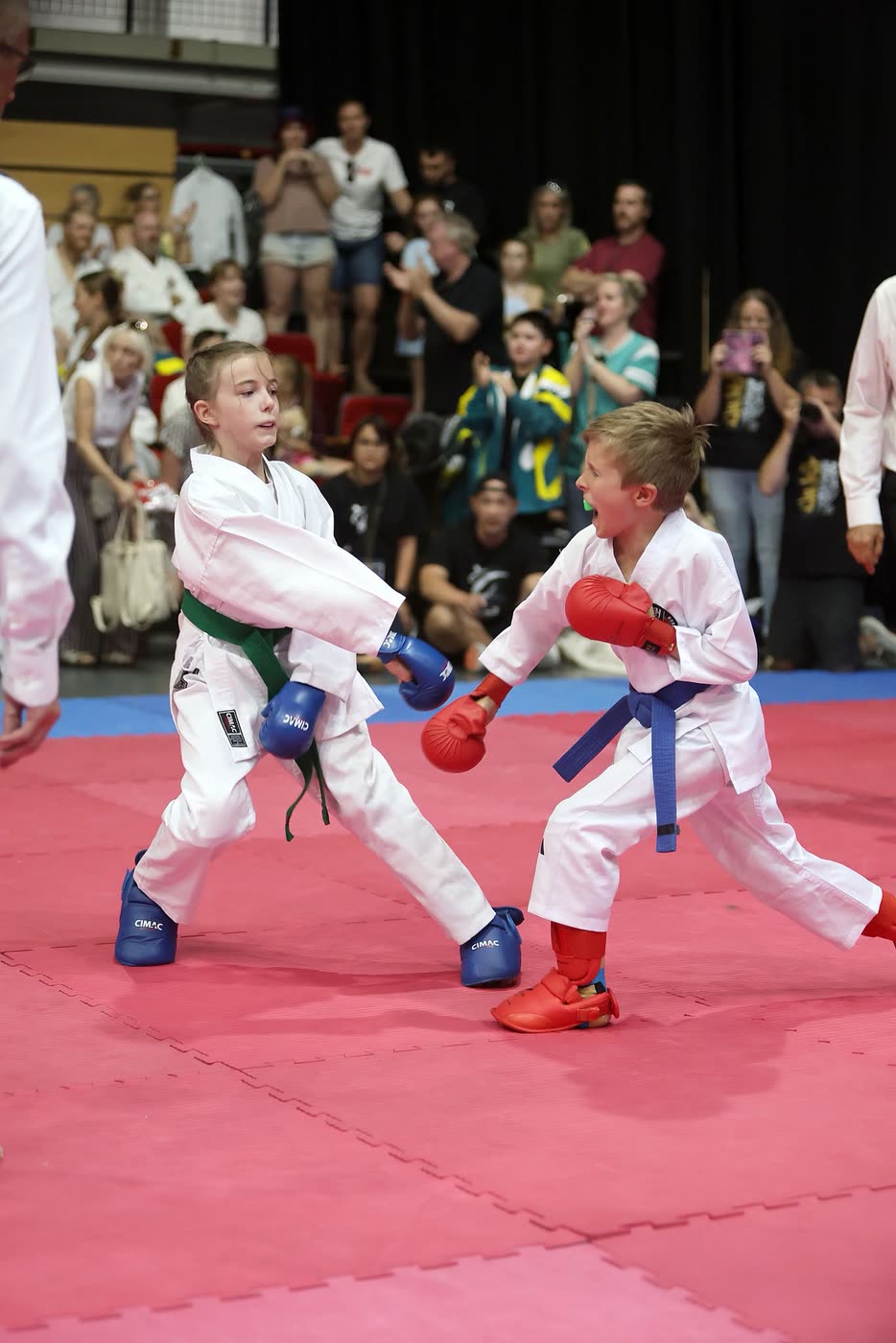 Two of the youngest competitors squaring off in red and blue gloves, mitts up.